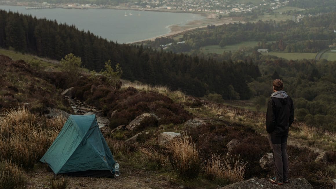 Jeune homme qui a dressé son bivouac par temps froid